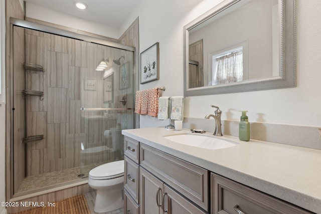 full bathroom with toilet, a stall shower, and vanity