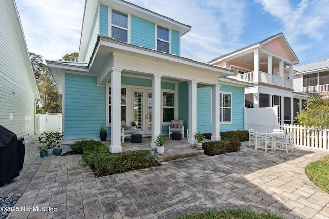 view of front of home featuring covered porch and fence