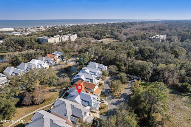 drone / aerial view featuring a water view, a residential view, and a wooded view