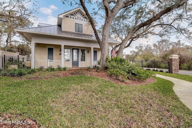 bungalow with metal roof, a standing seam roof, a front yard, and fence