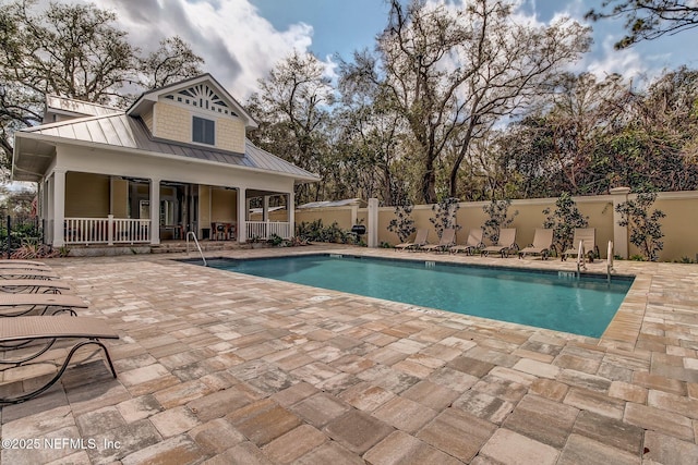 community pool featuring a patio area and fence