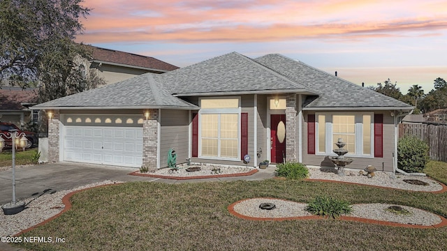 view of front facade with driveway, roof with shingles, an attached garage, a front lawn, and brick siding