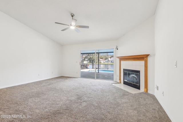 unfurnished living room featuring a tile fireplace, carpet floors, a ceiling fan, baseboards, and vaulted ceiling