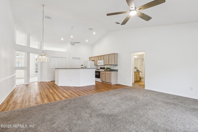 unfurnished living room with high vaulted ceiling, light colored carpet, visible vents, and a ceiling fan