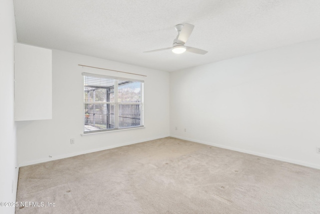 unfurnished room with ceiling fan, a textured ceiling, baseboards, and carpet flooring