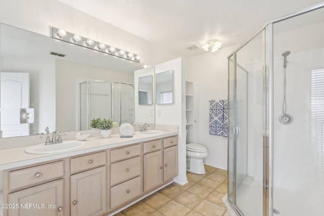 bathroom featuring double vanity, a stall shower, a sink, and visible vents