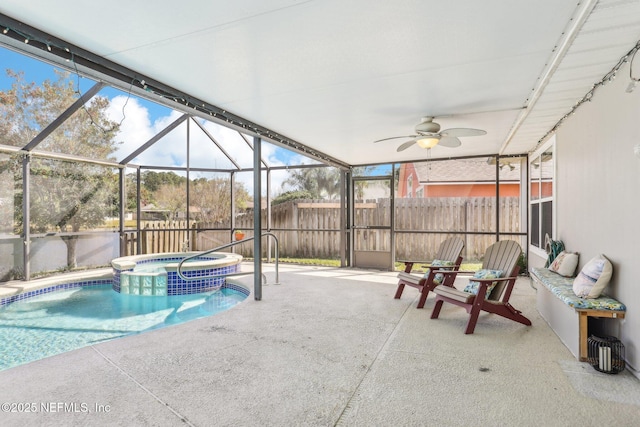 view of swimming pool with ceiling fan, a lanai, fence, a pool with connected hot tub, and a patio area