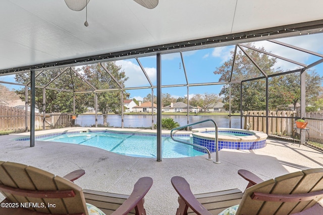 view of swimming pool featuring a patio area, a fenced backyard, a pool with connected hot tub, and a lanai