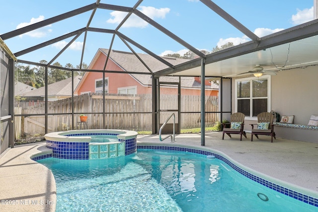 view of swimming pool with ceiling fan, a patio, a lanai, fence, and a pool with connected hot tub