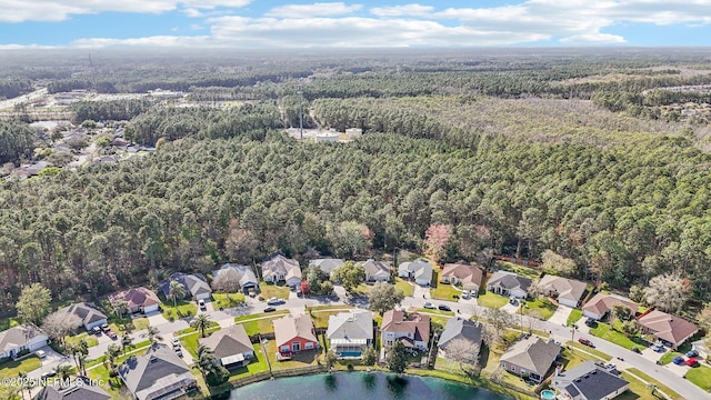 drone / aerial view featuring a residential view, a water view, and a forest view