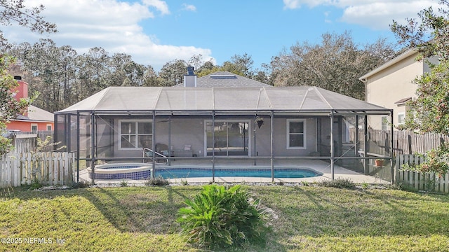 rear view of house with a patio, a fenced backyard, a lanai, a lawn, and a chimney