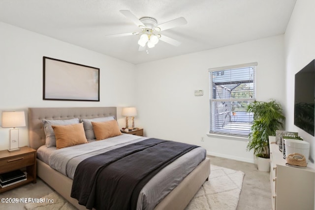 bedroom featuring baseboards, ceiling fan, and light colored carpet