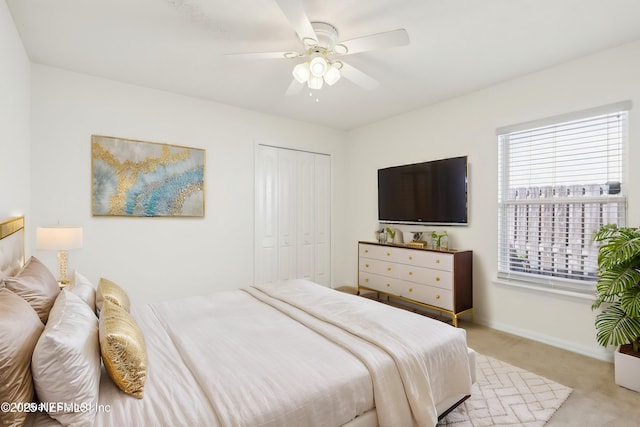 carpeted bedroom with a closet, a ceiling fan, and baseboards