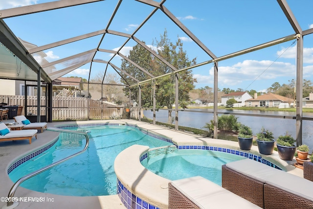 view of pool with a patio, a water view, a lanai, fence, and a pool with connected hot tub