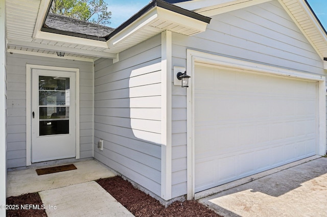 property entrance featuring a garage and a shingled roof