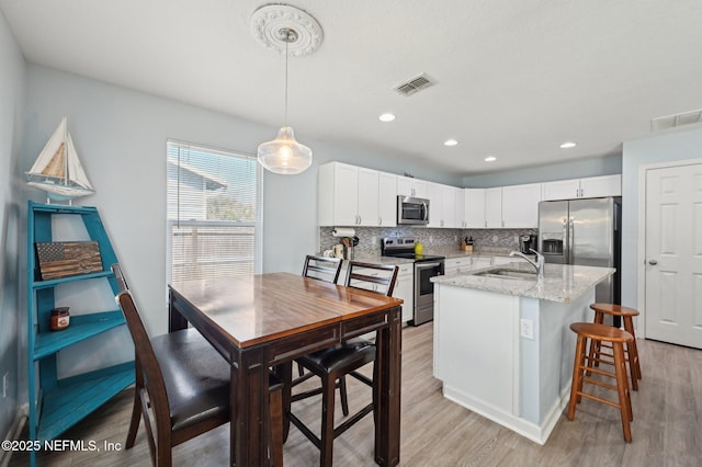 kitchen featuring visible vents, appliances with stainless steel finishes, backsplash, and a sink