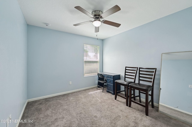 living area featuring carpet flooring, ceiling fan, and baseboards