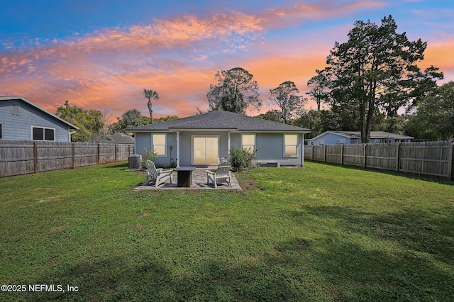 back of property featuring a fenced backyard, cooling unit, and a lawn