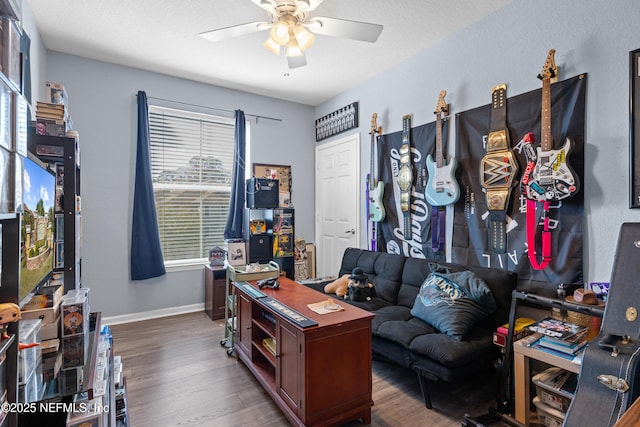 home office featuring a ceiling fan, a textured ceiling, baseboards, and wood finished floors