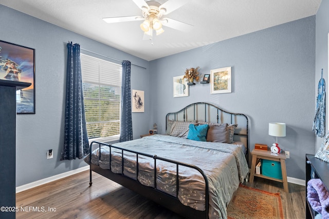 bedroom featuring a ceiling fan, baseboards, and wood finished floors