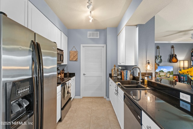 kitchen featuring light tile patterned floors, appliances with stainless steel finishes, visible vents, and white cabinets