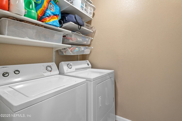 laundry room with laundry area, baseboards, a textured wall, and independent washer and dryer