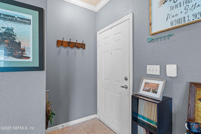 entrance foyer featuring ornamental molding, baseboards, and tile patterned floors