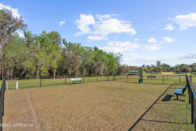 view of property's community featuring a lawn and fence