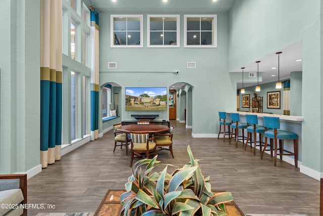 interior space featuring arched walkways, visible vents, and wood finished floors