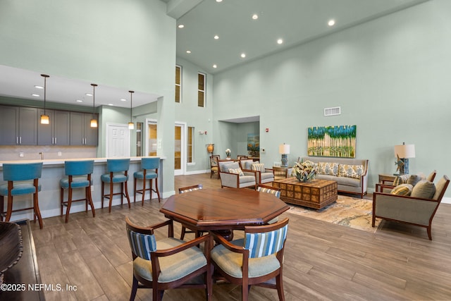 dining area featuring baseboards, wood finished floors, and recessed lighting