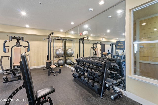 workout area with a textured ceiling, recessed lighting, and baseboards