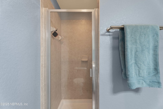 full bath featuring a stall shower and a textured wall