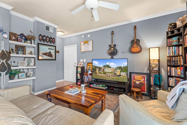 living room featuring wood finished floors, a ceiling fan, baseboards, visible vents, and crown molding