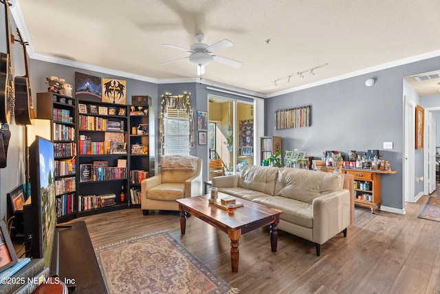 living room with ceiling fan, visible vents, crown molding, and wood finished floors