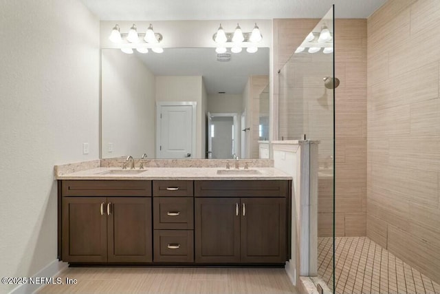 full bath with double vanity, a walk in shower, and a sink