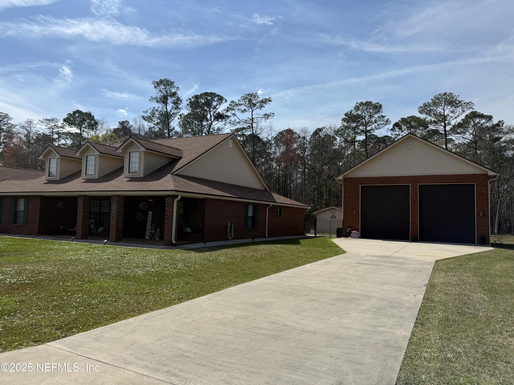 view of side of property with a yard, an outdoor structure, covered porch, and brick siding