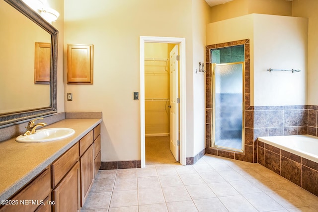 bathroom featuring a stall shower, tile patterned flooring, vanity, and a spacious closet