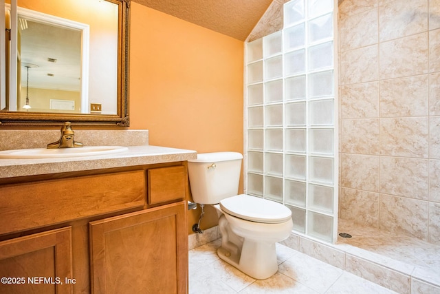 bathroom with a textured ceiling, tile patterned flooring, toilet, vanity, and walk in shower