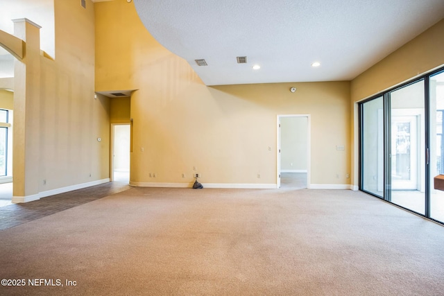 carpeted empty room featuring visible vents, recessed lighting, a wealth of natural light, and baseboards