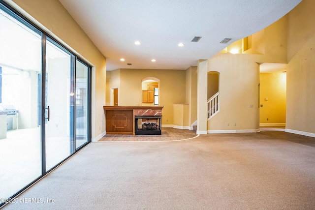 unfurnished living room featuring visible vents, baseboards, carpet, a fireplace, and recessed lighting