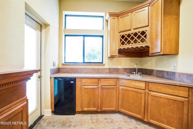 kitchen featuring refrigerator and a sink