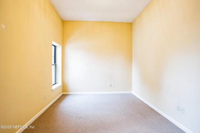 unfurnished room with carpet floors and baseboards