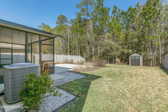 view of yard with an outbuilding, a storage shed, a fenced backyard, and central air condition unit