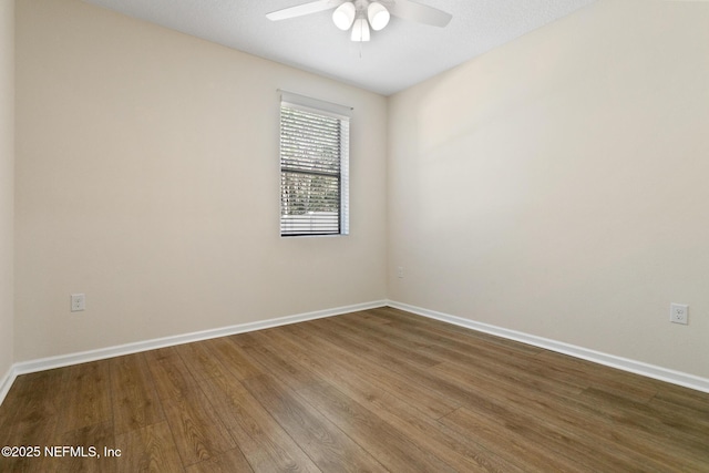 spare room with a ceiling fan, baseboards, and wood finished floors