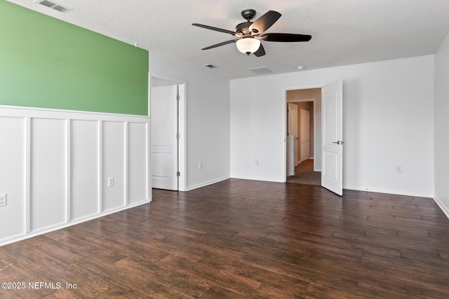 spare room featuring a textured ceiling, visible vents, and wood finished floors