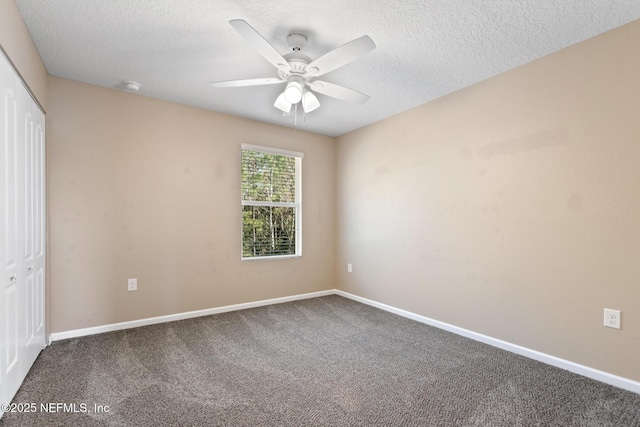 unfurnished bedroom with carpet floors, a textured ceiling, baseboards, and a closet