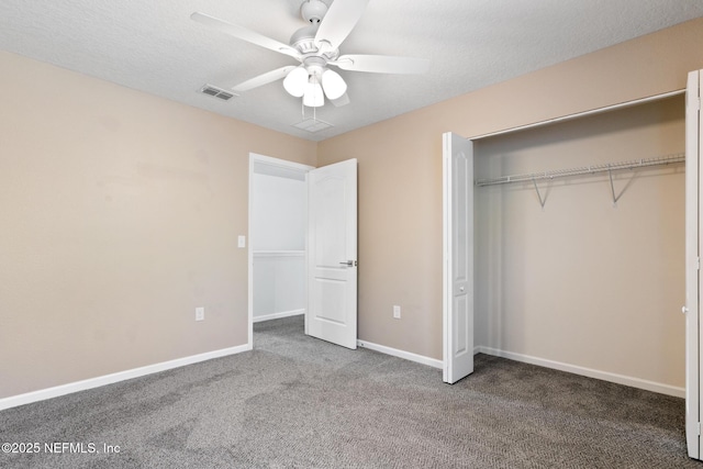 unfurnished bedroom with a closet, visible vents, carpet flooring, a textured ceiling, and baseboards