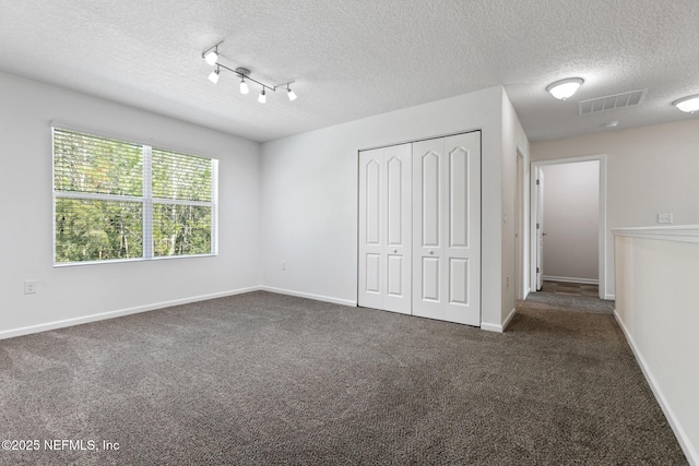 unfurnished bedroom featuring carpet floors, a closet, visible vents, and baseboards