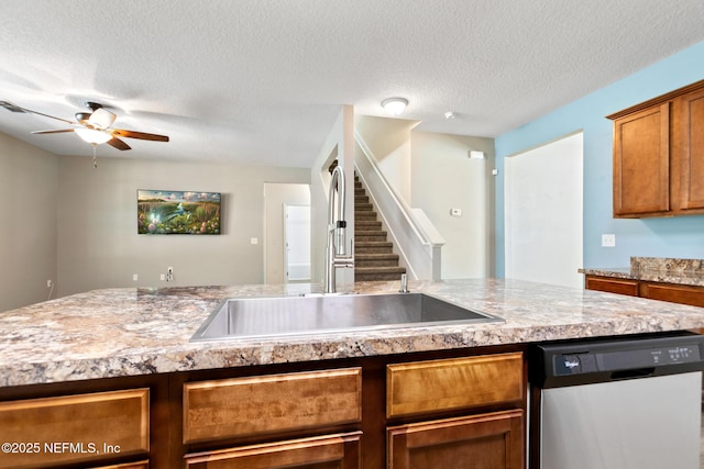 kitchen with brown cabinetry, dishwasher, ceiling fan, light countertops, and a sink