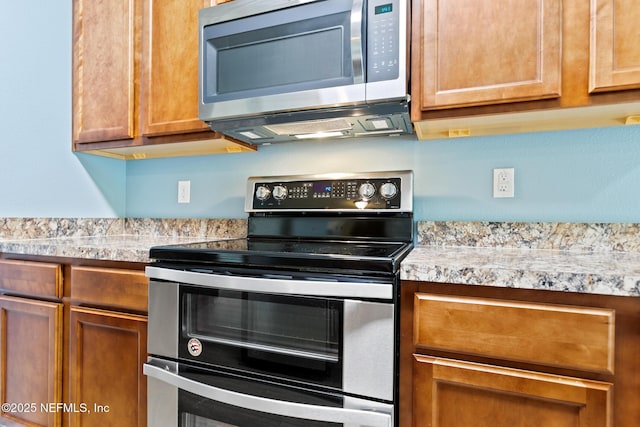 kitchen with brown cabinetry, stainless steel appliances, and light countertops